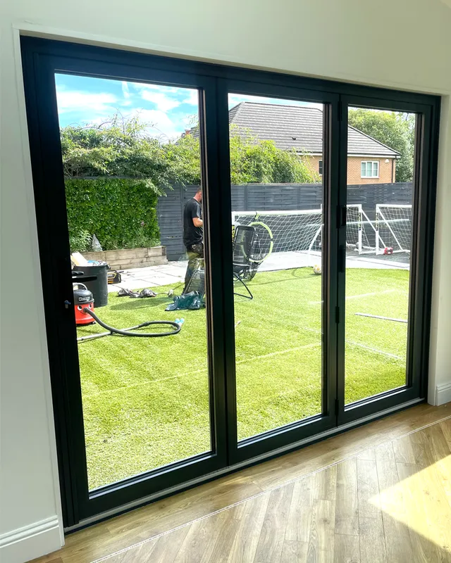 Black aluminium bi-fold doors opening onto a garden
