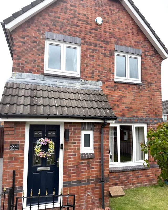 Brick home with white Veka uPVC windows and a composite front door